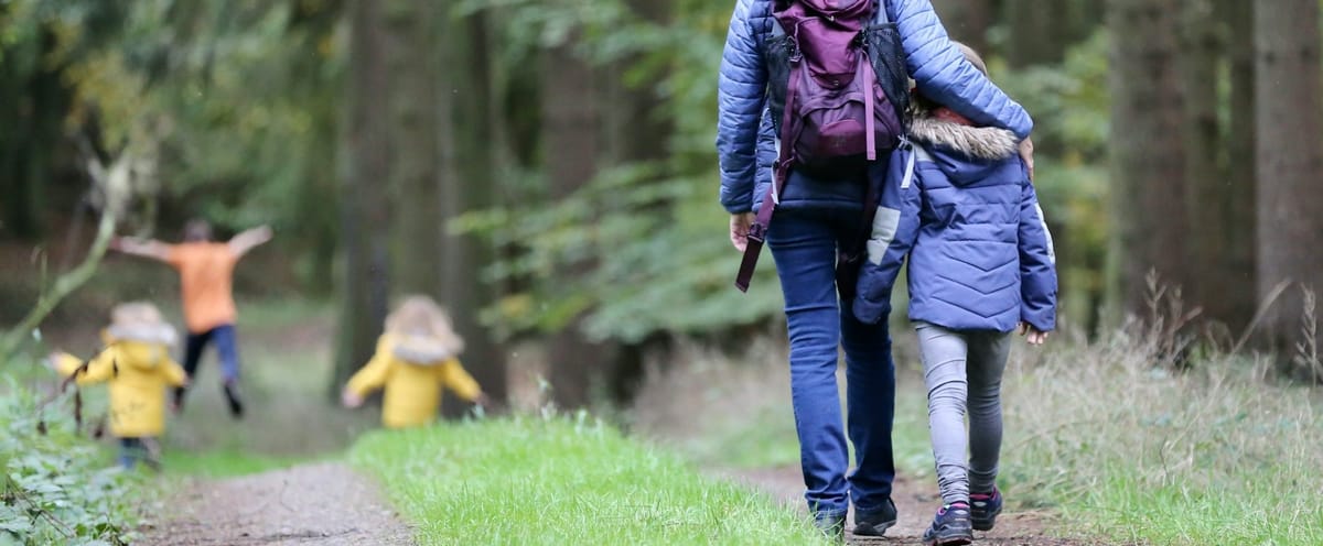 Header image of a parent and child walking on a trail